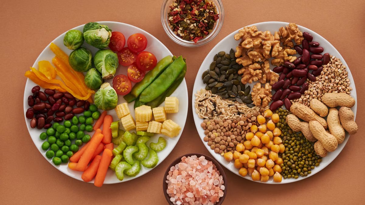 Vibrant display of assorted vegetables, legumes, nuts, and seeds on plates, perfect for healthy eating images.